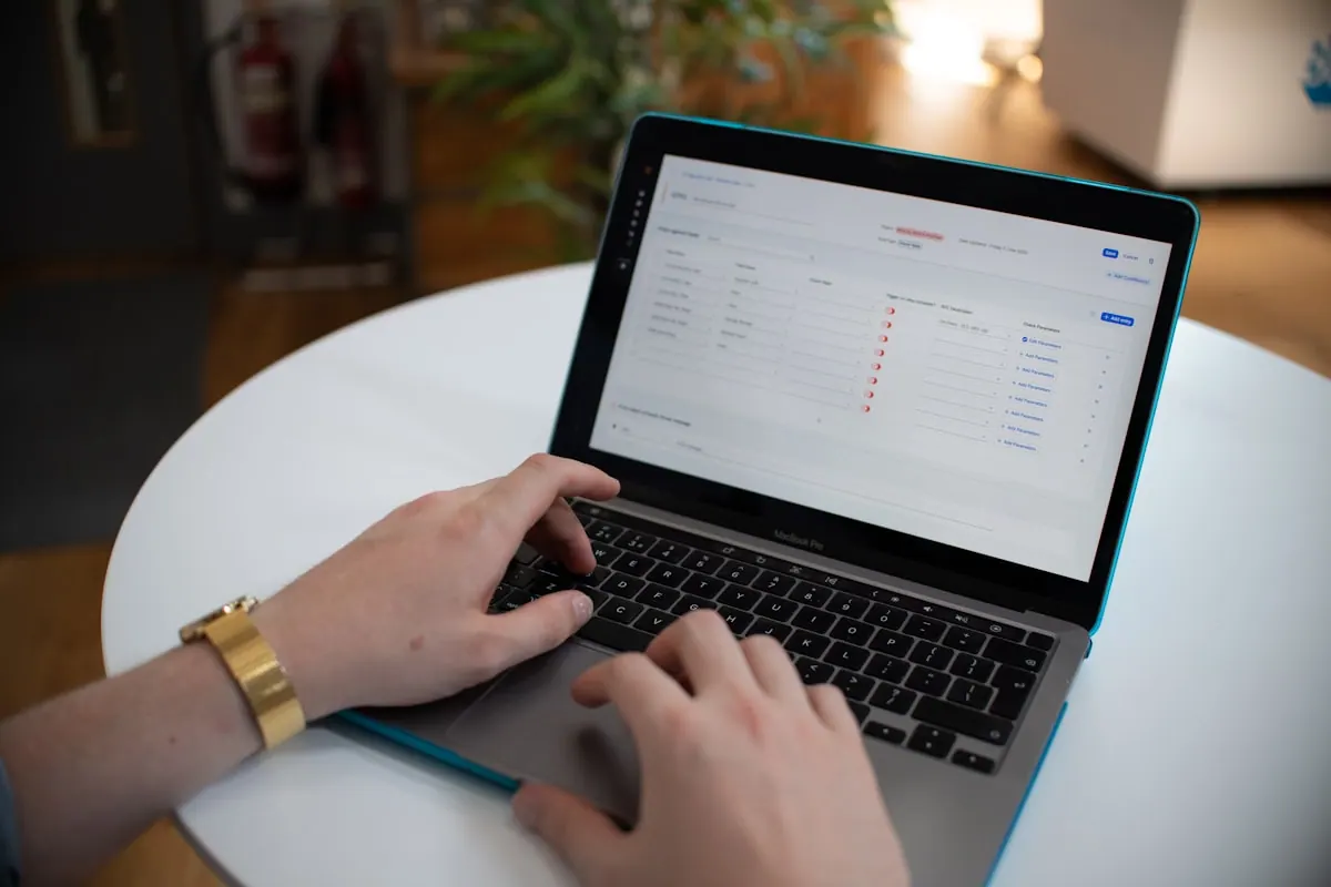 Hands using a laptop with a spreadsheet on screen