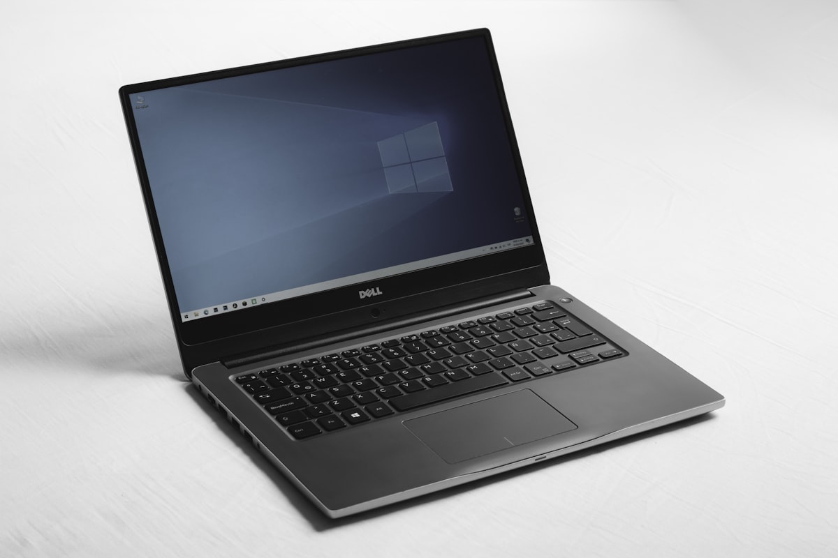 A Dell laptop with a blue desktop screen on a