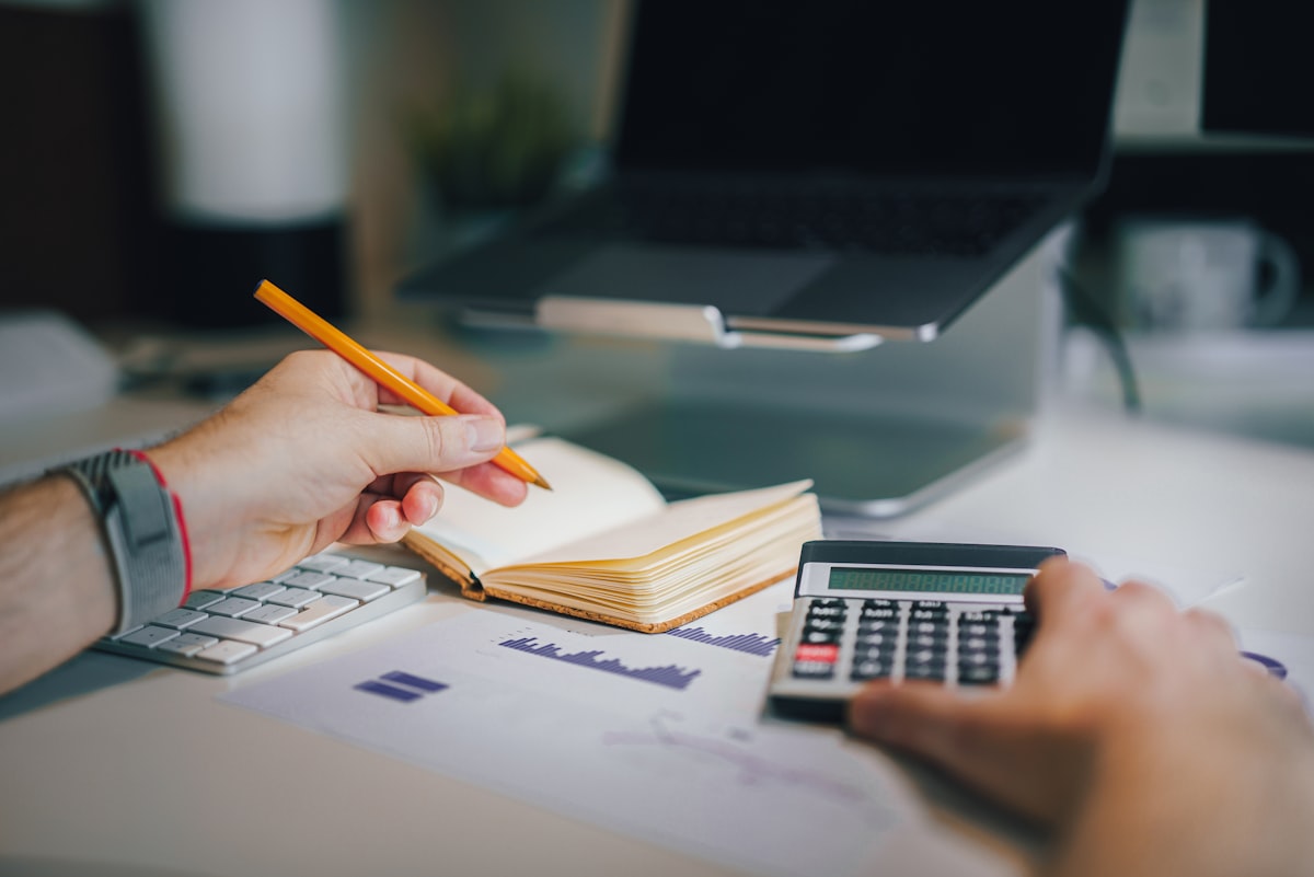 a person sitting at a desk with a calculator